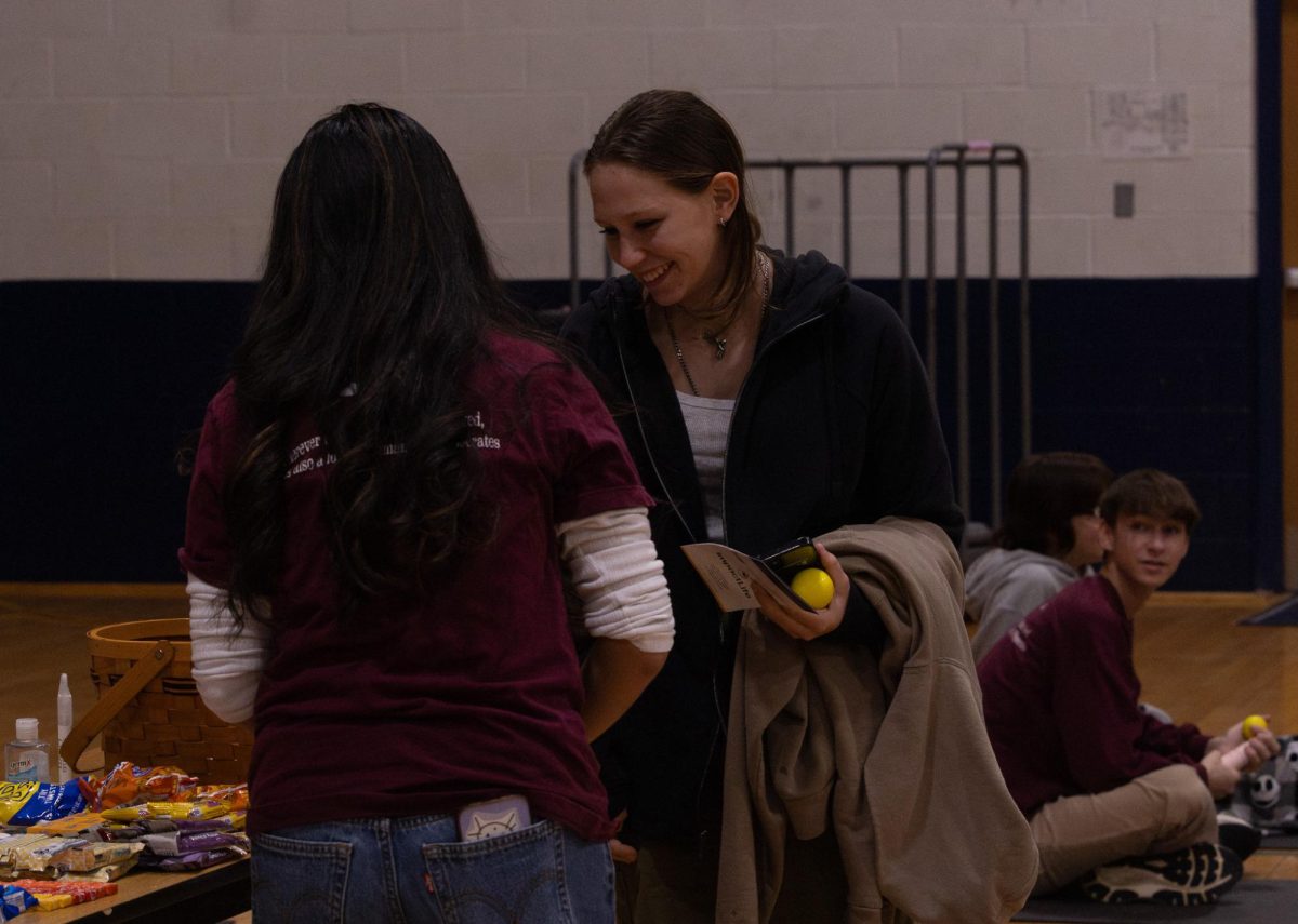 Huynh speaks with junior Eliza Martin at the blood drive. Huynh's involvement at this event eased the process for all involved.
