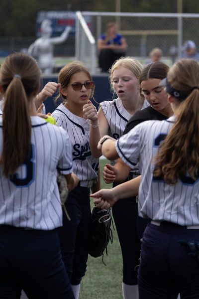 Sophomore Lila Johnson and freshman Lilly Call lead the team in a pregame huddle. Before their last JV game of the season on Oct. 13th, the team creates a plan for the game.
