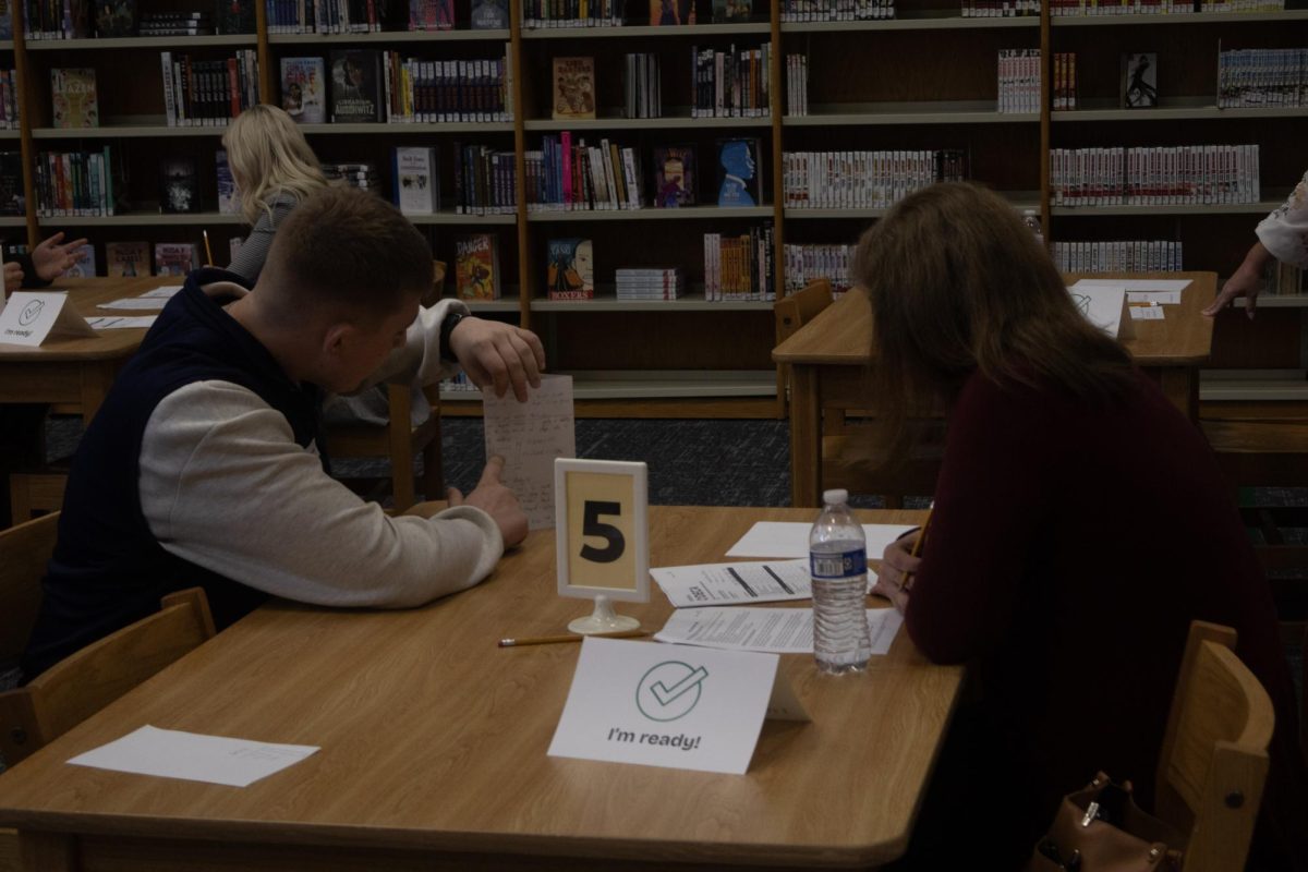 Senior Dimitry Babey sells his idea for improving NCAA ticket sales to a judge at the DECA competition on Nov. 19. Babey shows his social speaking and business skills by gesturing to his paper.