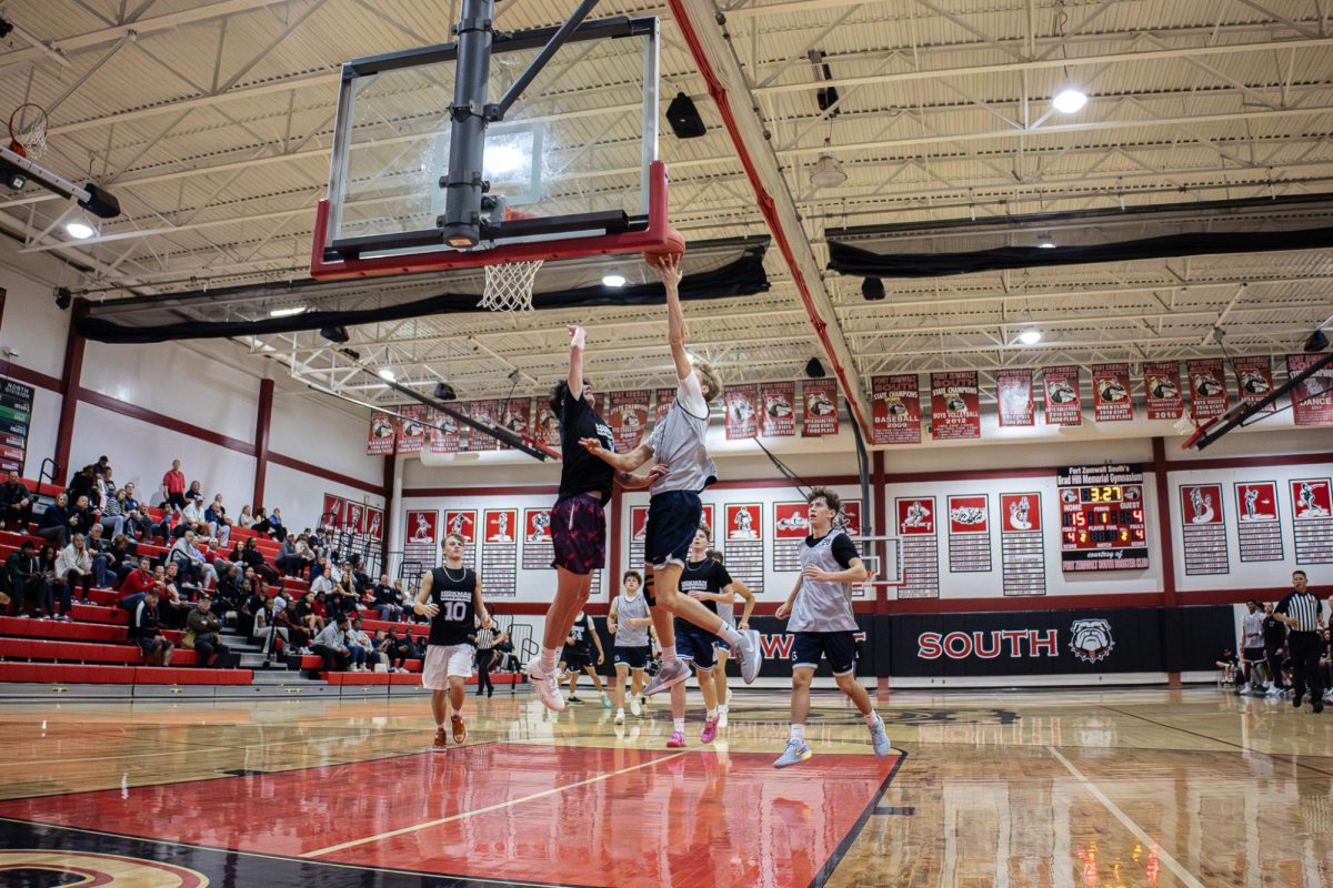 On Nov. 20, Junior Ryan Halterman jumps to dunk the ball into the hoop. He awarded the team 2 points putting them in the lead.