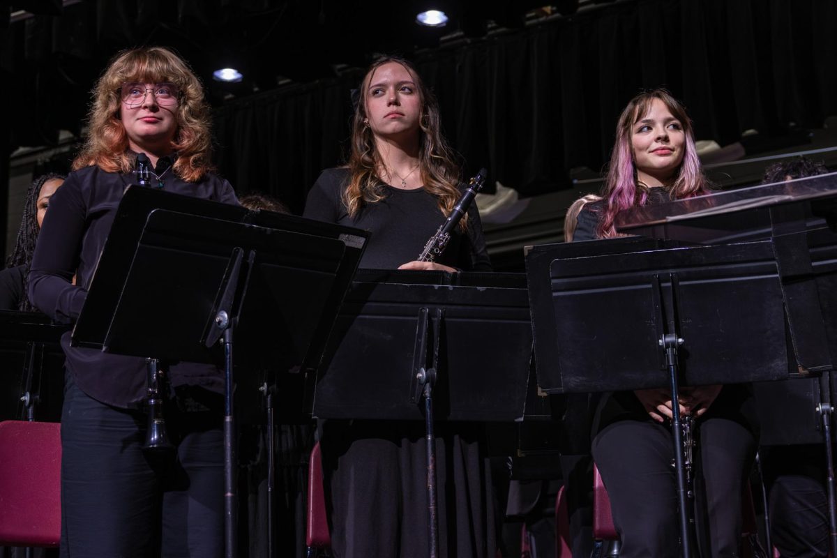 On Dec. 9, junior August Fallert, sophomore Kailey Smith, and junior Ceci Gilfoil prepare to play clarinet for their upcoming performance. The Wind Ensemble entered the stage after the Symphonic Band put on their performance.