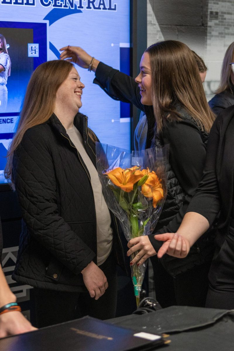 On Dec. 9, junior flute player Sydney Mursesan hugs her aunt holding flowers. Concluding the Symphonic band performance, many relatives congratulated students with flowers and other gifts.