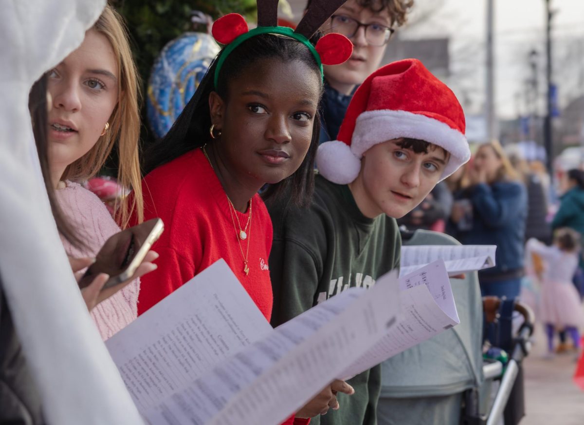 Preparing for their next song on Dec. 6, juniors Mari Jones and Ben Freitas glance towards junior Megan Chiu as they decide upon the next song to sing. Since they had already performed most of their usual carols, the students found it difficult to select the following tune.