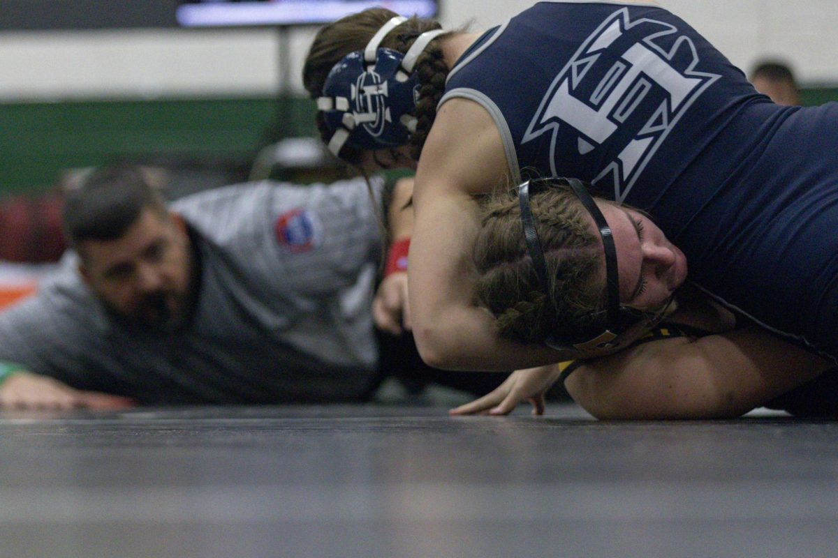 On Dec. 5, sophomore Harper Humes holds her opponent's head with her arm to initially keep her down. The ref is looking closely to see if she will win the match, and with this pin, she does.