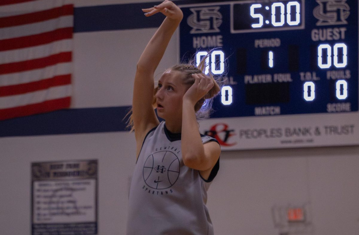  In warmups for the jamboree, junior Elle McDevitt tosses the ball to the hoop. She flicks her wrist and jumps to practice her positions for the game on Nov. 18.