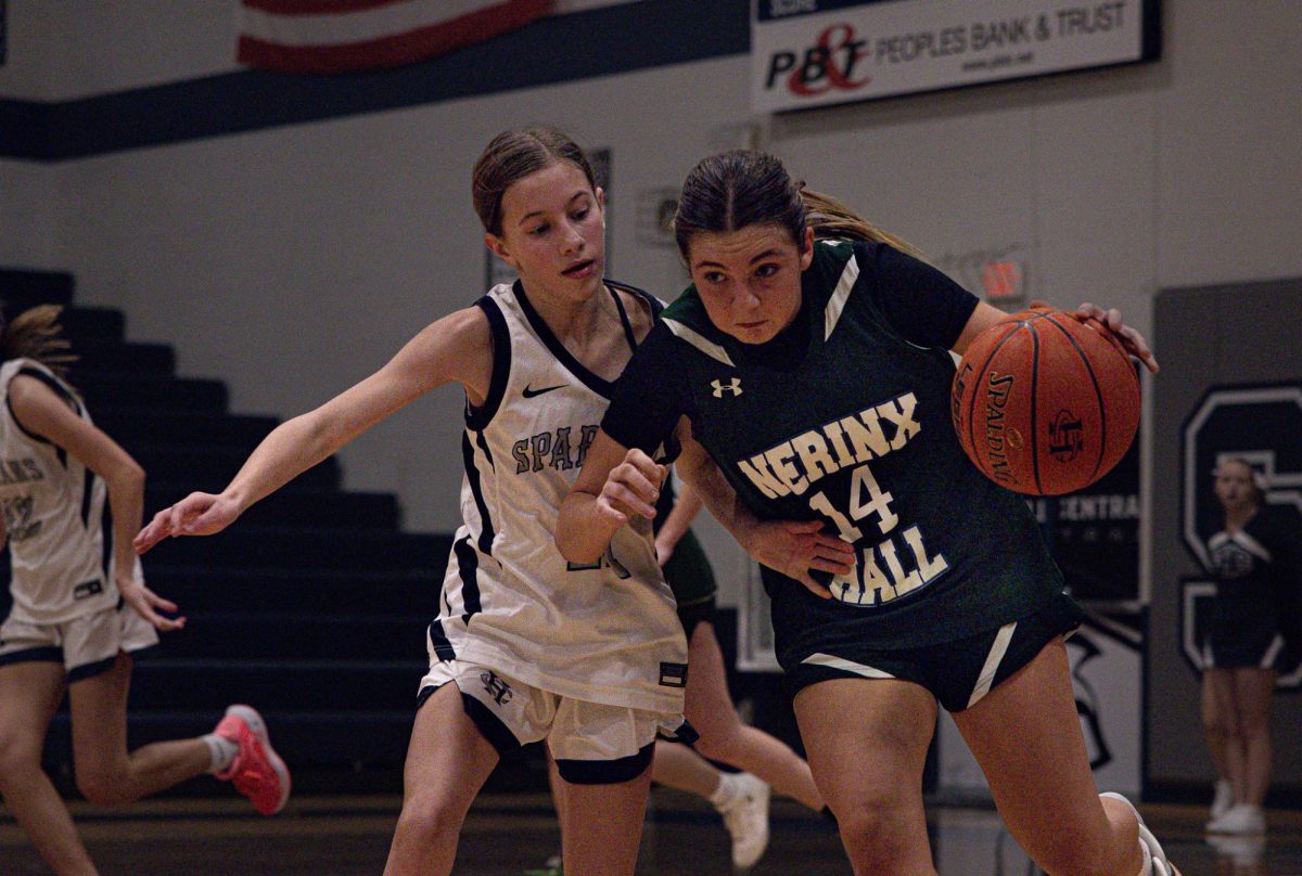 Defending a player from Nerinx Hall in their game against them on Nov. 25, Adrienne Winters puts pressure on the opposing player. Stopping the player from getting an open court allowed FHC to maintain their lead through the game.