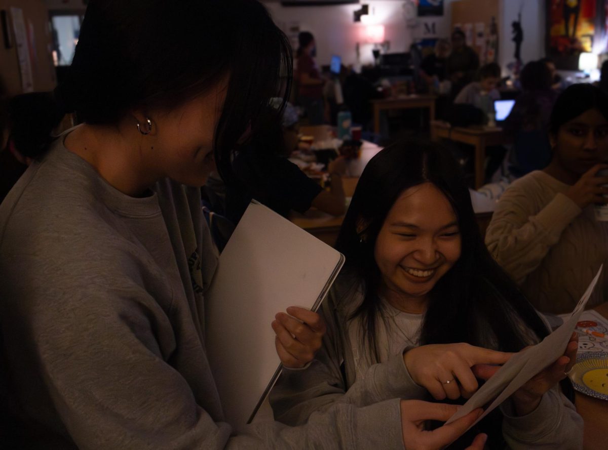 Juniors Anna Shi and Megan Chiu laugh and smile at each other as they show each other their artwork during the Nov. 11 NAHS meeting. Both Shi and Chiu colored pictures for each other during the snack and color. 