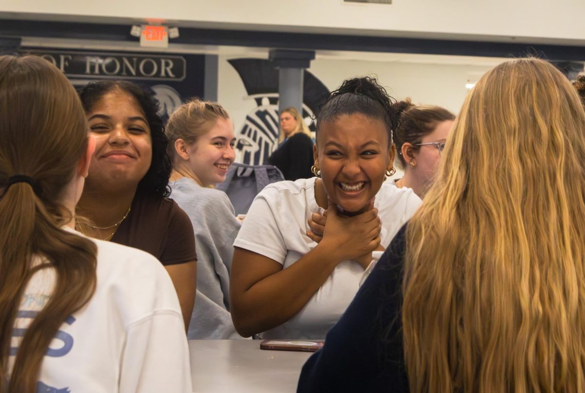 Junior Afomia Tensae jokes around with her friends during the Arete breakfast on Nov. 21. After being disappointed multiple times when her ticket number wasn’t called out, she still had hope for a different outcome.