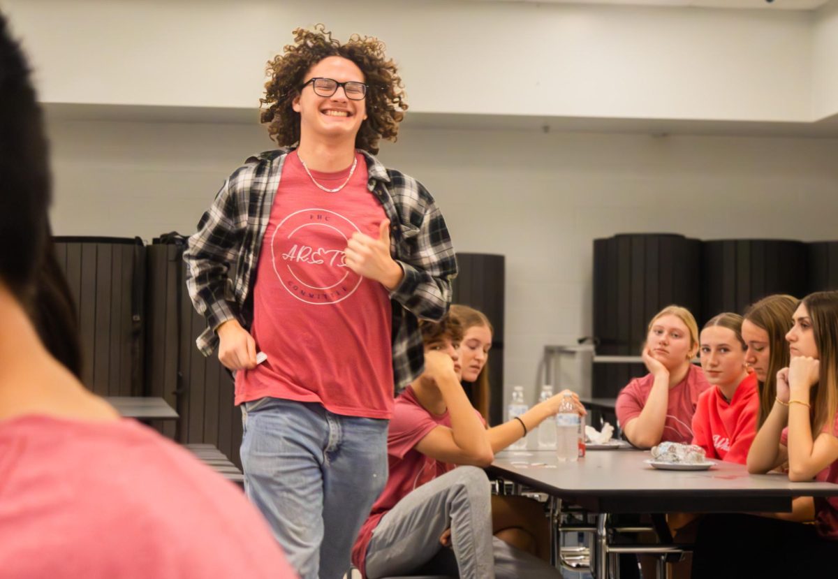 Senior Michael Purcell runs to pick a gift card at the Arete breakfast on Nov. 21. Forgetting his ticket, he had to go back to his table to grab it and race back up.