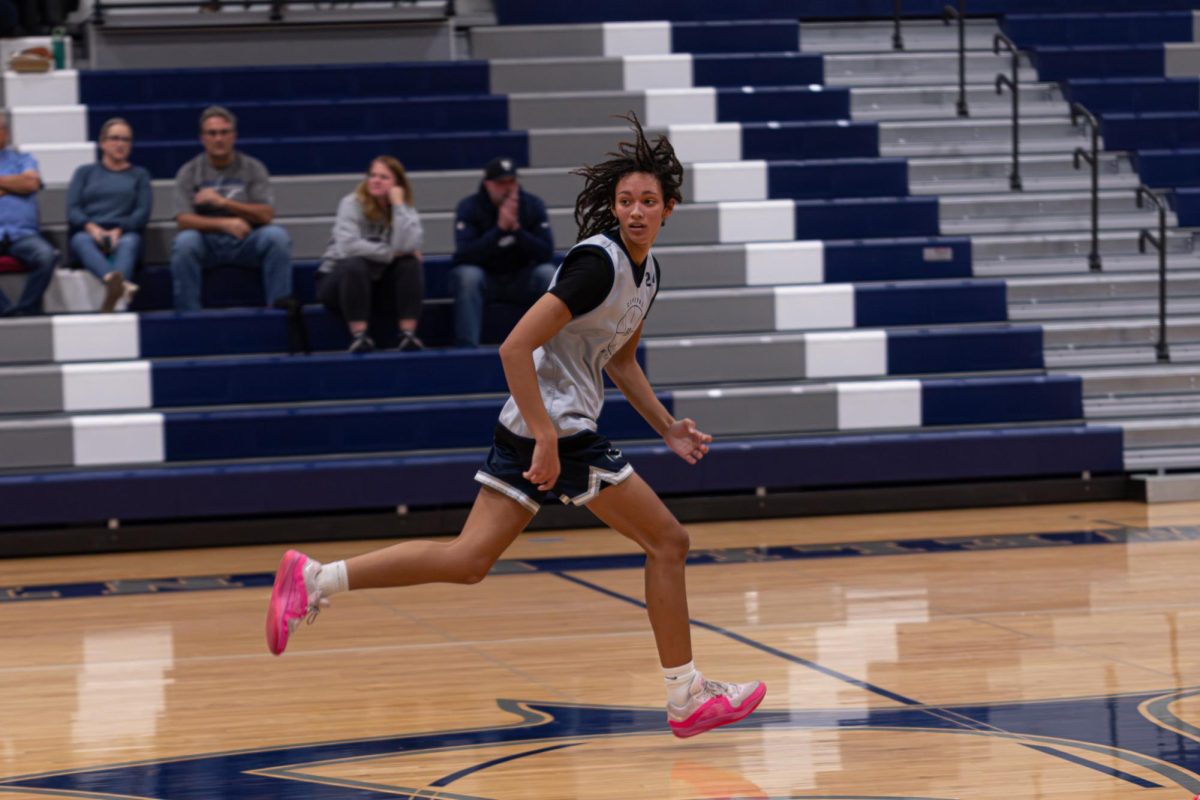 With speed and concentration on Nov. 26, junior Jayla Robinson sprints down the court keeping up with her team. As she watched every play happen, she focused on the ball every time it got passed.
