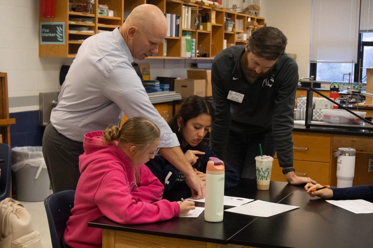 Both teachers McCoy and Jury talk with freshman Lily Donton and Sophie Ledesma Jaimes after a couple minutes of discussion they decide to ask the teachers for help. Both teachers stand next to the desk and prompt them with questions to better help them.