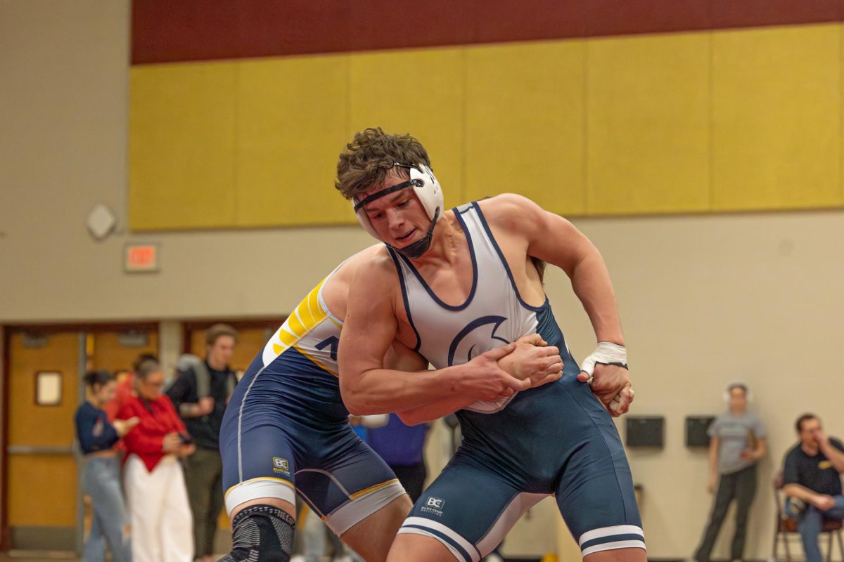 Trying to get his escape point, junior Gavin Groves hits a stand-up move and circles the mat as he works to loosen his opponent's hands. Groves eventually hips out and gets his escape point and then circles the mat to look for his next move.   

