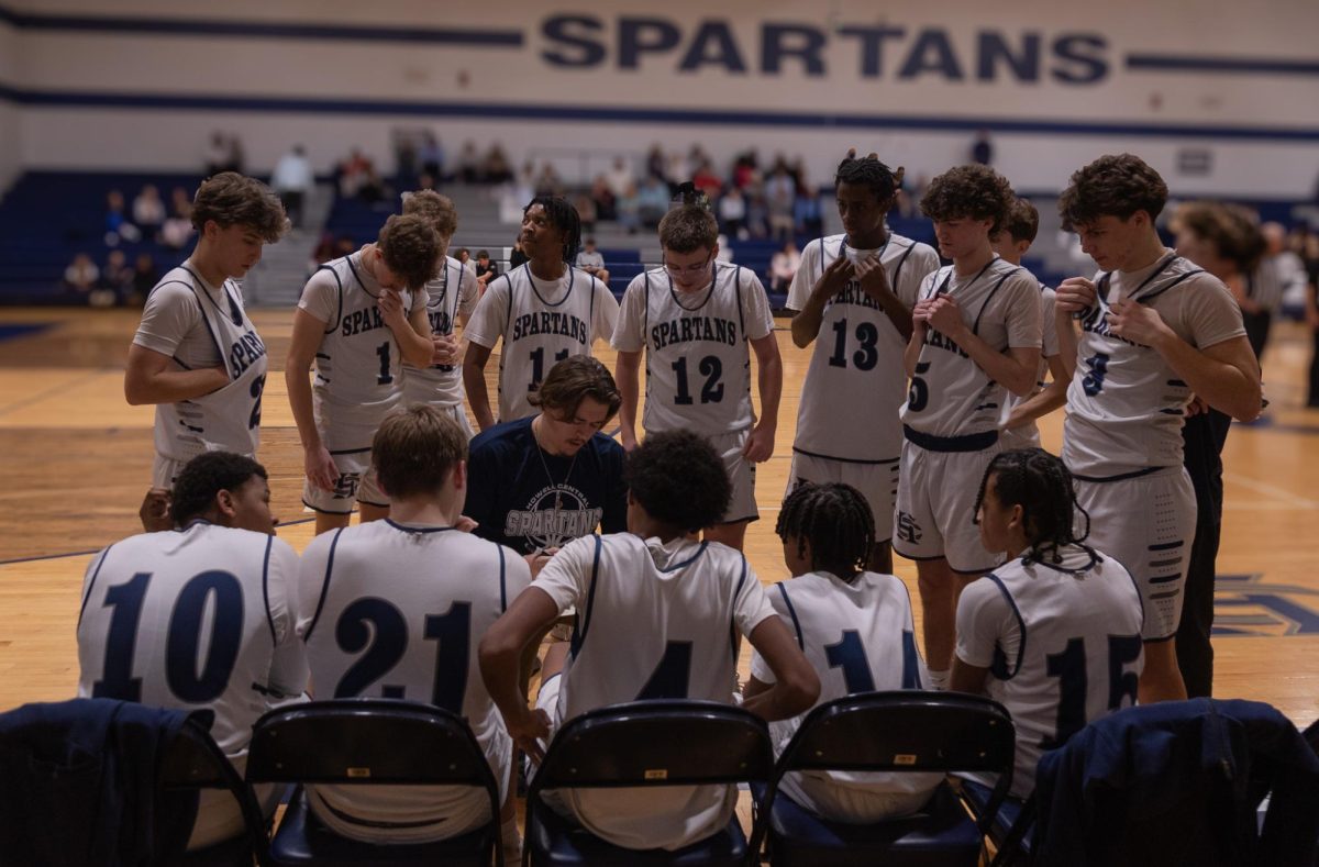 The Spartans take a breather on the bench while head Coach Kade Sissel draws up the next play. Coach Sissel outlines a Zone-defense.
