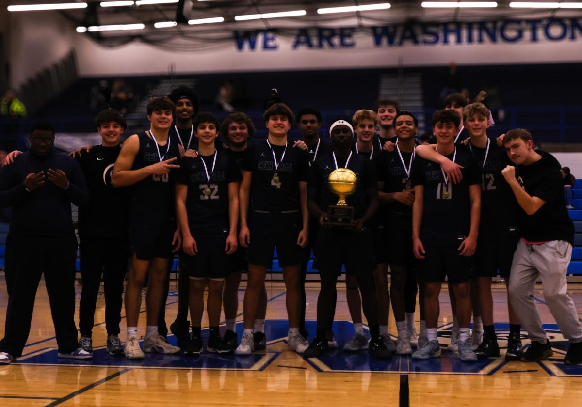The team poses at half court with the Washington Tournament Championship trophy on Jan. 16. The players can also be seen wearing their first place medals.
