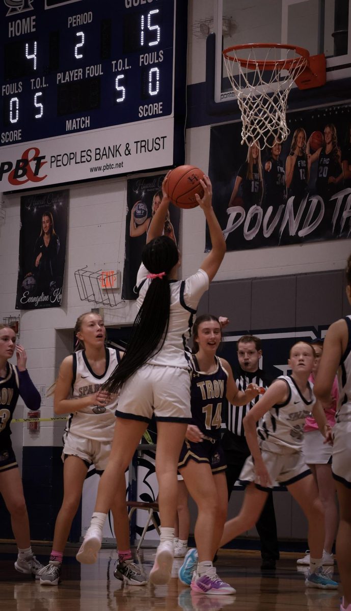 Leaping off the floor towards the Spartans basket, freshman Kinley Hiles aims to make a shot at the Jan. 9 game. As a forward, Hiles's main focus in the games was controlling the ball near the net.
