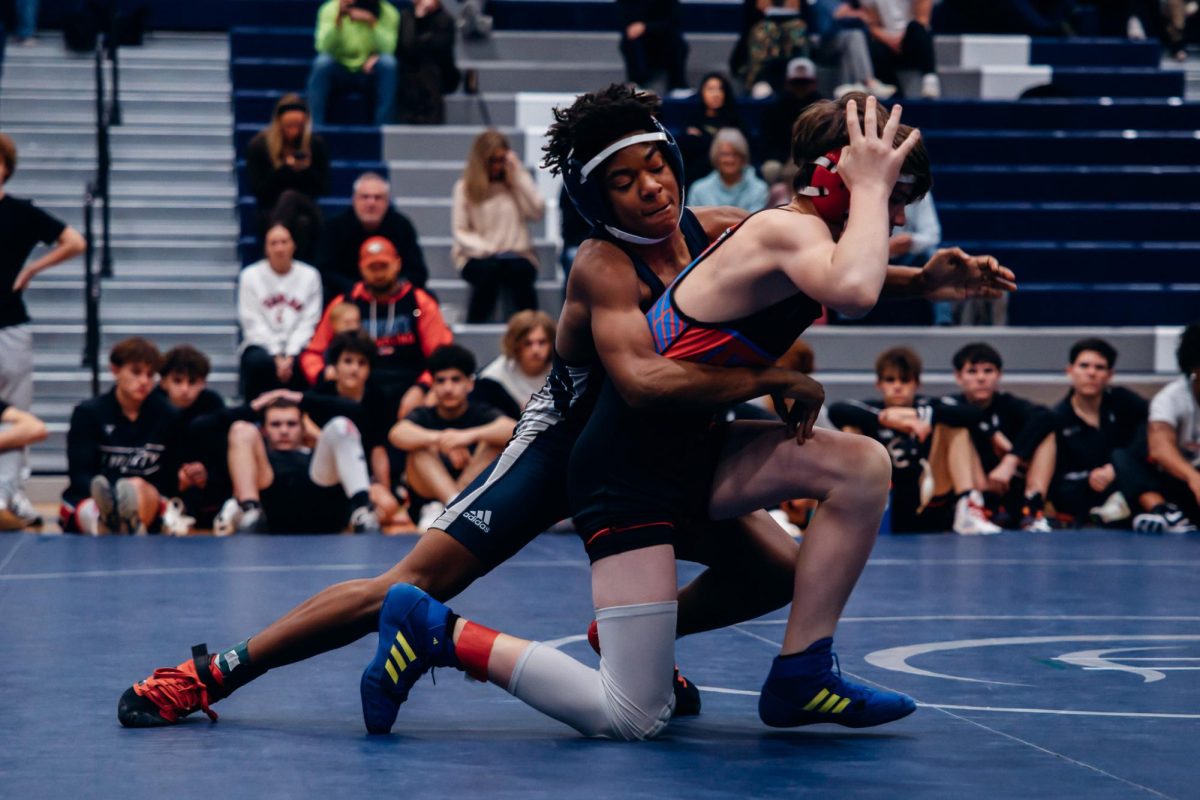 On Jan. 7, freshman Dorian Watson performs a takedown against Liberty. Ending the first match in a loss, Liberty took the point. 