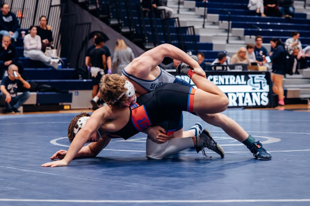 Junior Sam Golden grabs his opponent's leg on Jan. 7, in an attempt to pin him. Golden won the point for the match making the score between Central and Liberty even. 