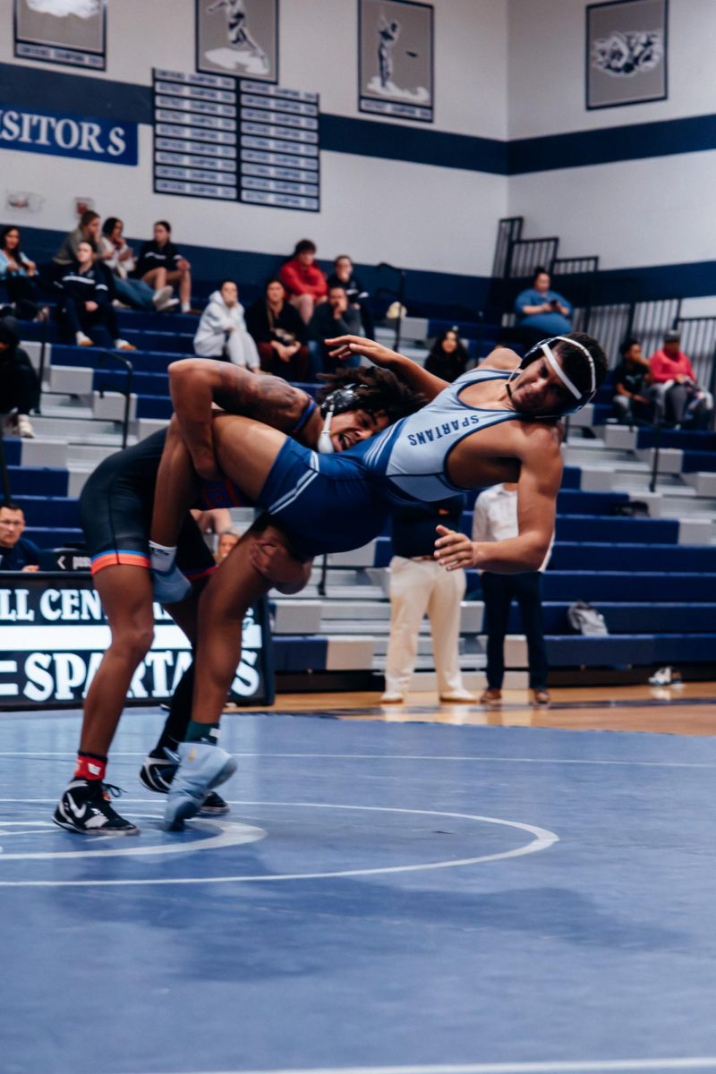 On Jan. 7, senior Garo Sams prepares for impact as Liberty player performs a double leg. After hitting the mat, Sams was pinned but was able to successfully evade winning the point. 