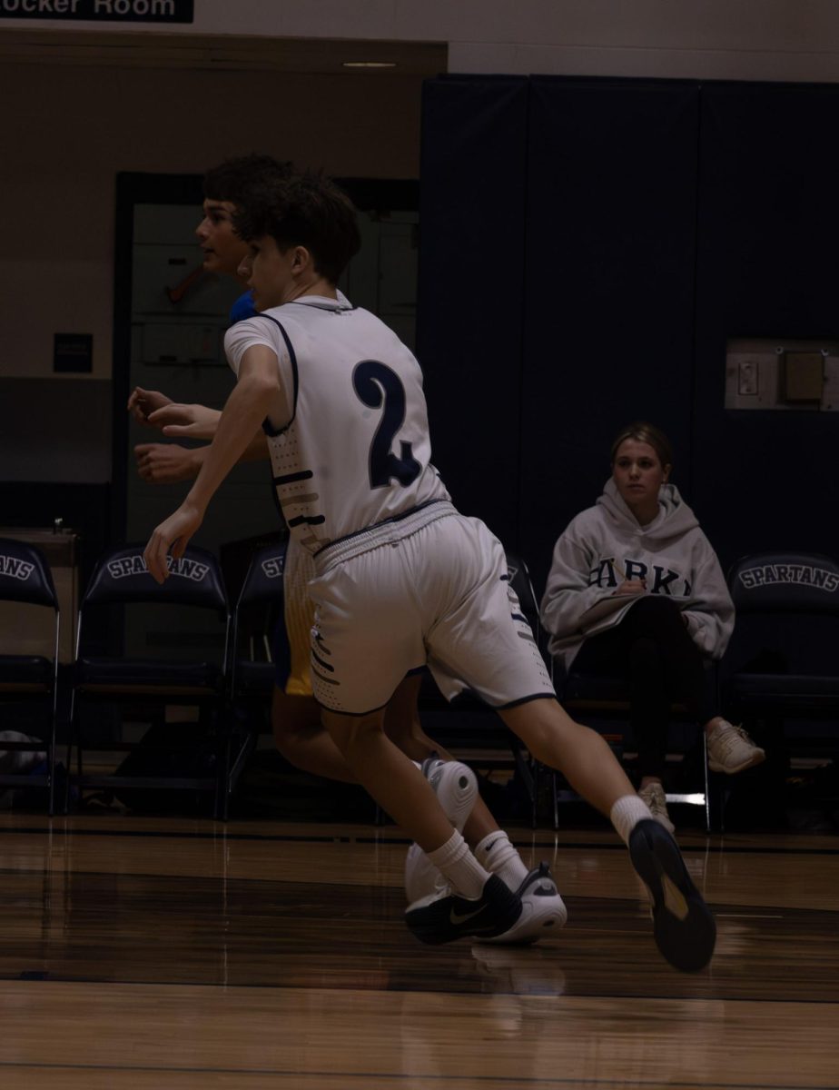 On Jan. 8, freshman Tanner Hackmann watches the ball's movement and follows it with precision. Hackmann ran towards the ball to make a pass to his teammates on the court.