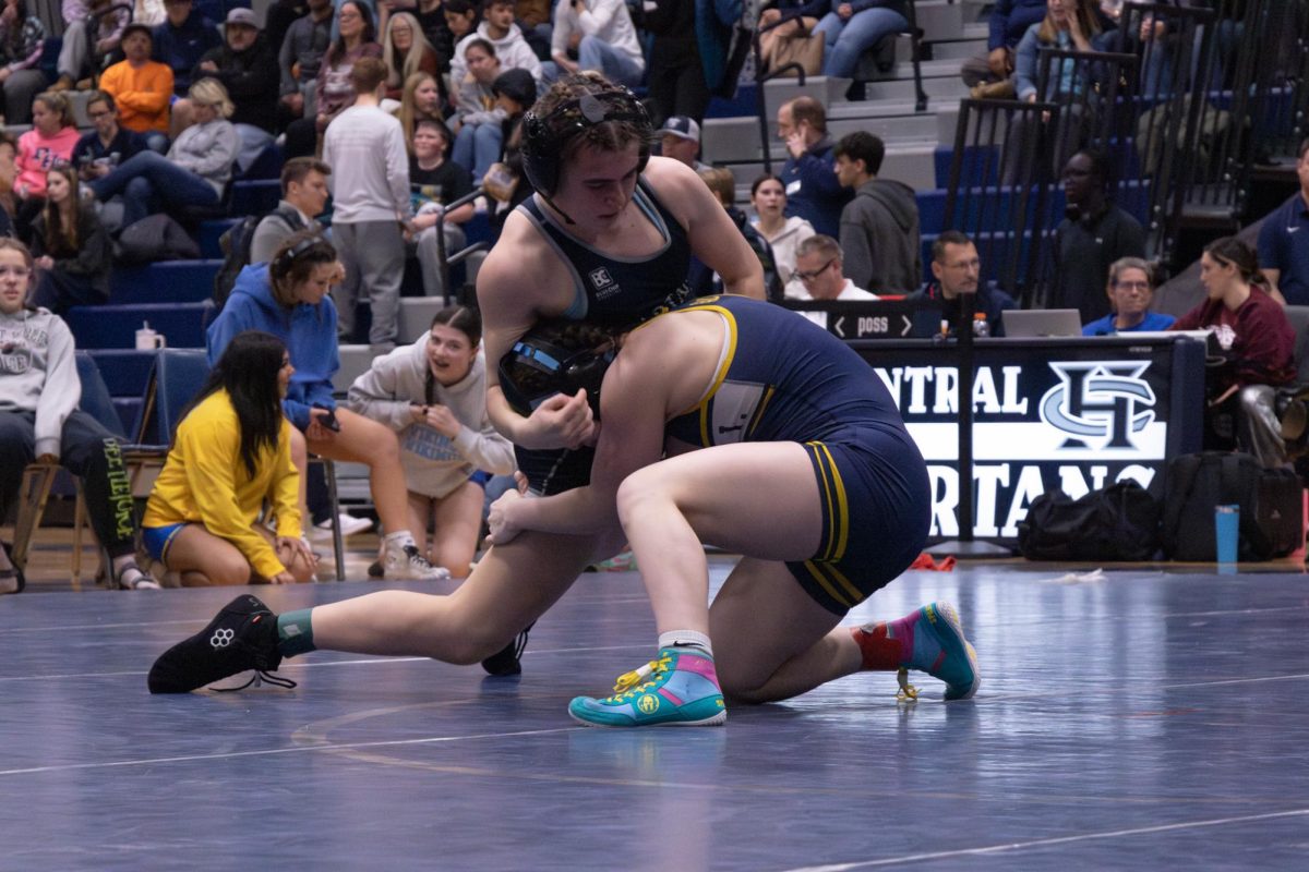 As she was grabbed by her opponent from Howell, sophomore Kaitlyn Sparkman wraps her arm around her opponent's head. Sparkman slid her knee forward and quickly pinned her opponent to the mat on Jan. 14.