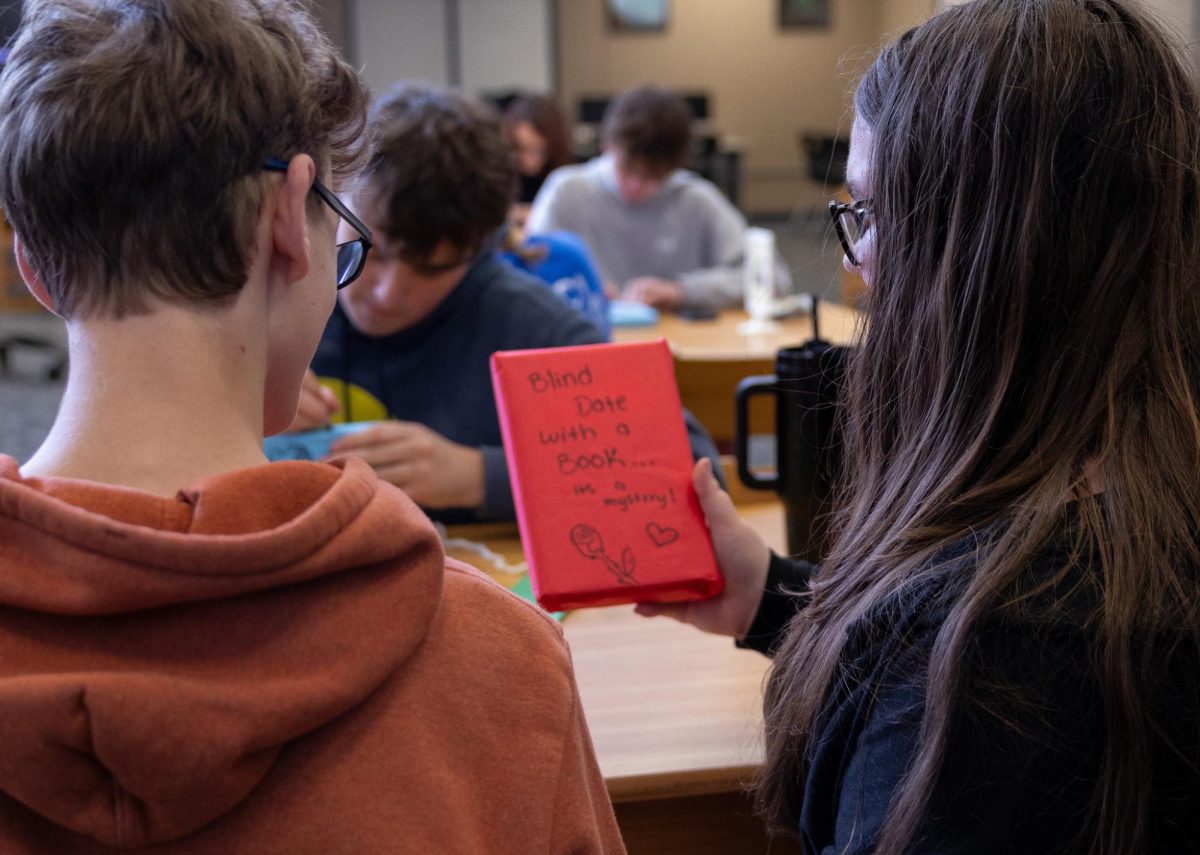Book in hand, junior Jordan Zambrzuski shows her completed “Blind Date with a Book” to sophomore Louis Feiler on Feb. 18. Although Feiler isn’t a part of the club, Zambrzuski encouraged him to participate in the activity and experience Epsilon Beta.
