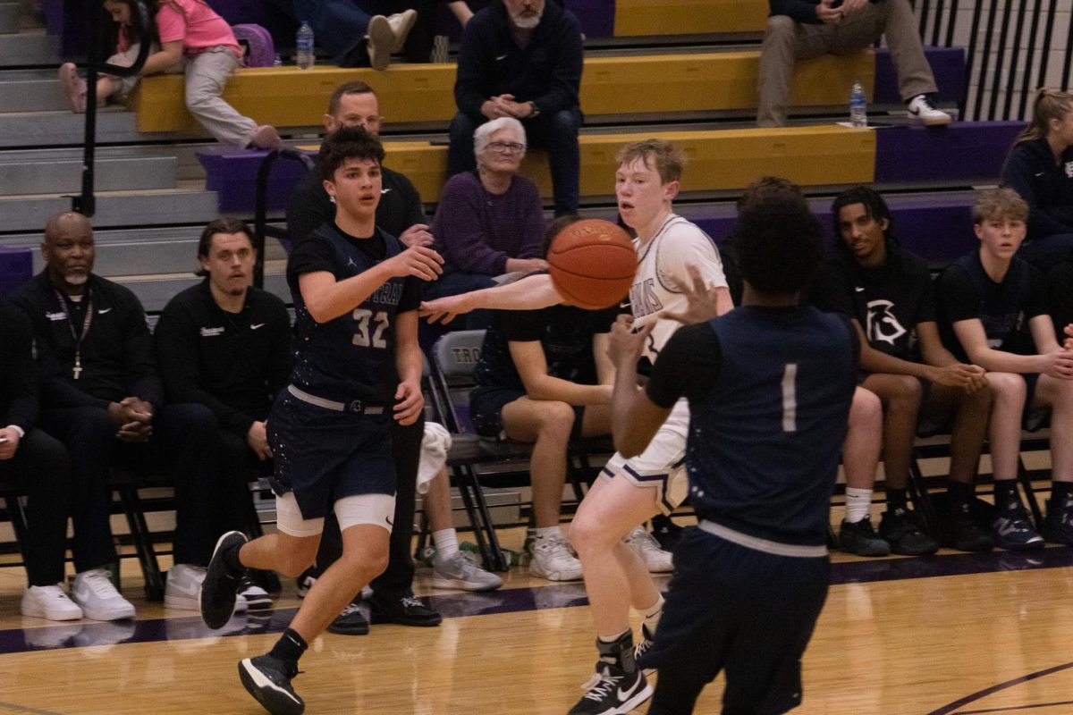Passing the ball to his teammate at the game on Feb. 10, senior Tyson Hackmann makes sure to make a good pass so the other team can't get the ball. The team made sure to pass the ball around and find the right time to shoot. 

