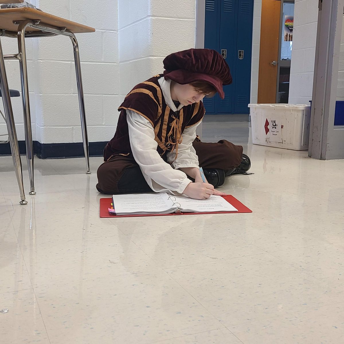 Making notes in a script, stage manager Jack Lesch sits on the floor in a classroom preparing for a production. Lesch's hard work and attention to detail led to the opportunity to work backstage for a production at the Fabulous Fox Theatre in St. Louis.
