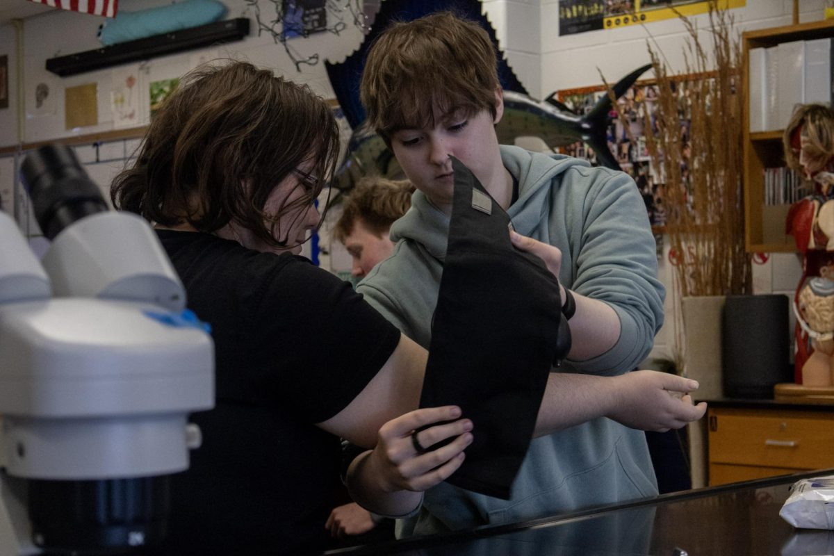 Senior Adam Miller places a blood pressure cuff around the arm of senior Oliver Robins in preparation to take blood pressure on Feb. 23. Before taking each other’s blood pressure students were instructed by Mr. Reed to put the cuff on loose enough to fit one finger inside comfortably, but not so loose that it would fall down. 