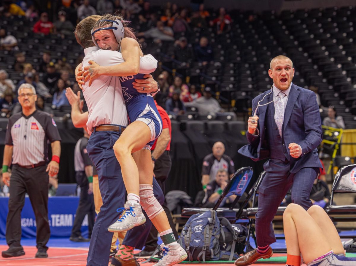 After getting a big upset and pinning her opponent, junior Addison Holtgrew ran over to assistant coach Brian Bitney. Holtgrew then went to find her dad on the floor and celebrate her big win with him.   