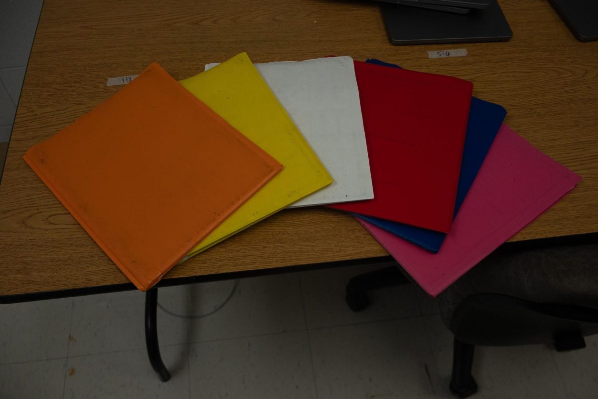 Students folders displayed by class hour on desk. Students place colors with their classrooms to help feel more organized in their scholastic day. 