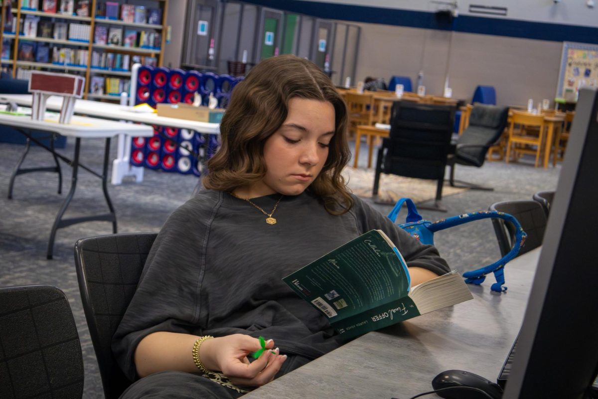 Senior Sophie Poenicke sits and reads a book during her flex hour on March 3. Poenicke can be found with her nose in a book when she has a free moment to escape from reality. 