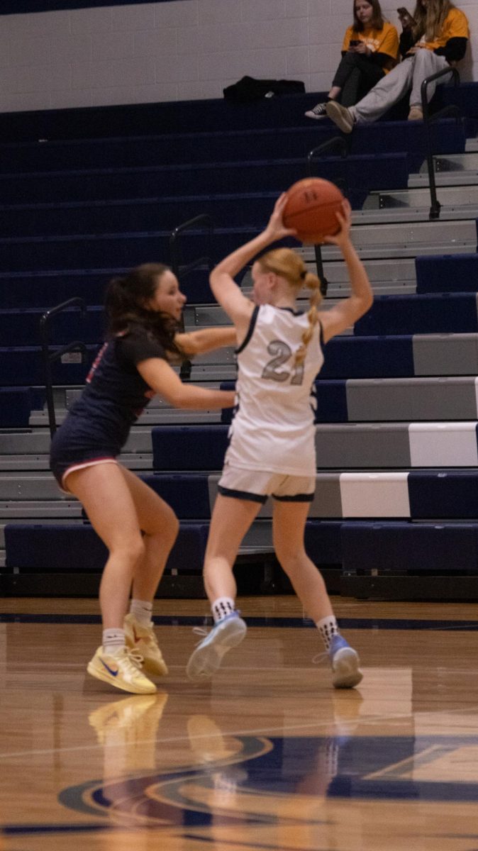  Freshman Chloe Bond holds the ball above her head on Feb. 17 as the Liberty opponent attempts to steal it from her.