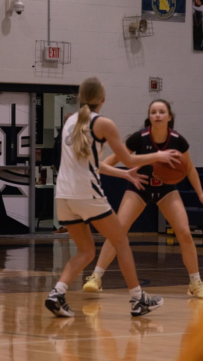  Dribbling down the court, freshman Nyla Collins passes her opponent on Feb. 17 taking the ball down the court and attempting to score a point.