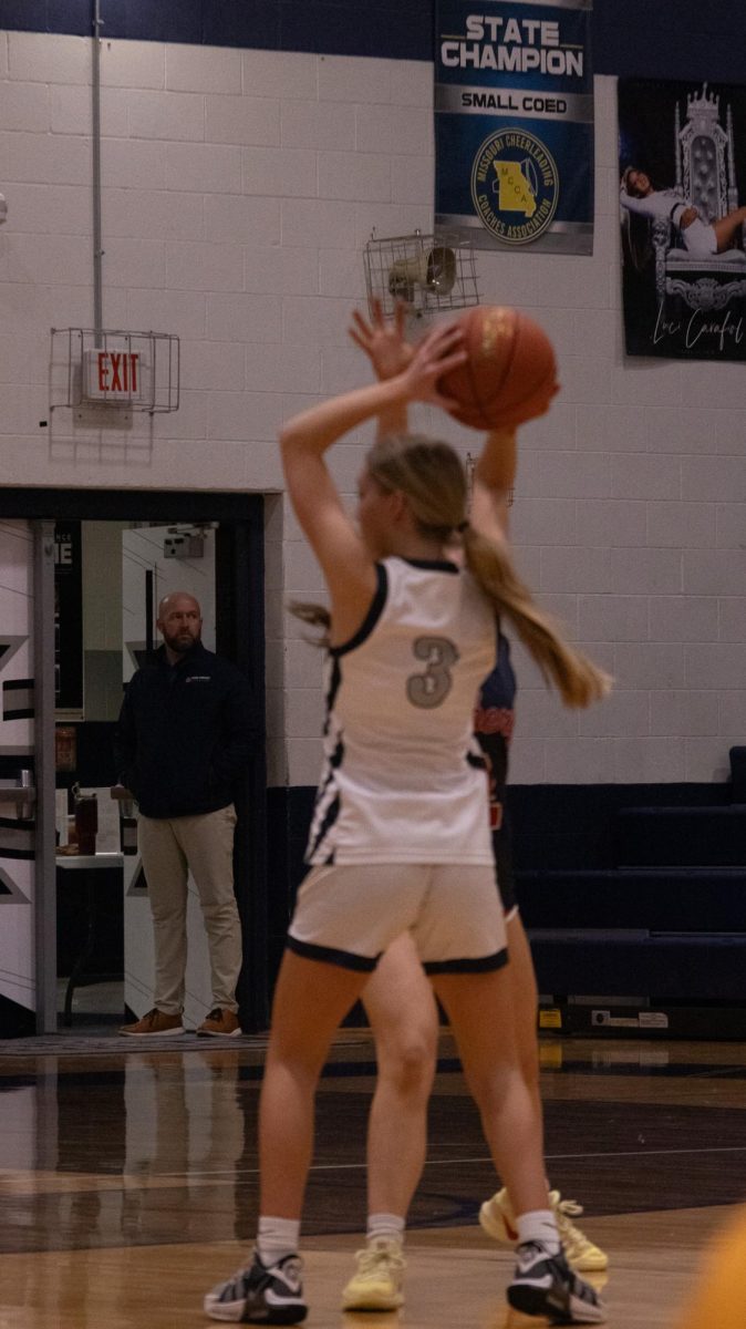  She raises the ball above her head on Feb. 17  to keep it just out of reach of the opponent. The liberty player extends her arm up trying to knock the ball out of Collins hands.