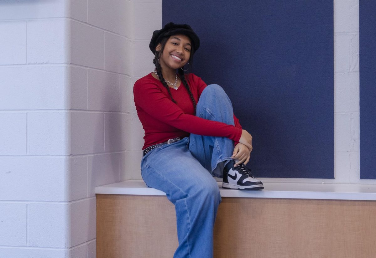 Taylor sits comfortably near the auditorium. Her style is a mixture of Y2K and preppy.