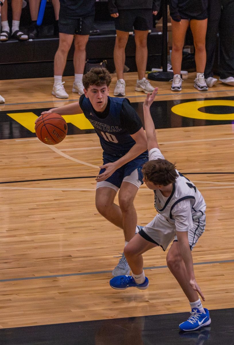 Junior Jayden Tucker dribbles the ball into the paint against Howell North on Mar. 27. Tucker makes a drive toward the basket for a layup.

