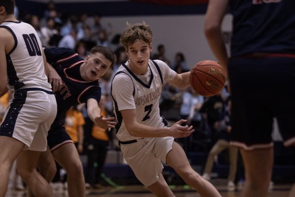 Junior Jack Brown sets a screen for junior Ryan Halterman, allowing him to slip past during the game on Feb. 17. The defender reaches out in a futile attempt to stop Halterman from scoring.