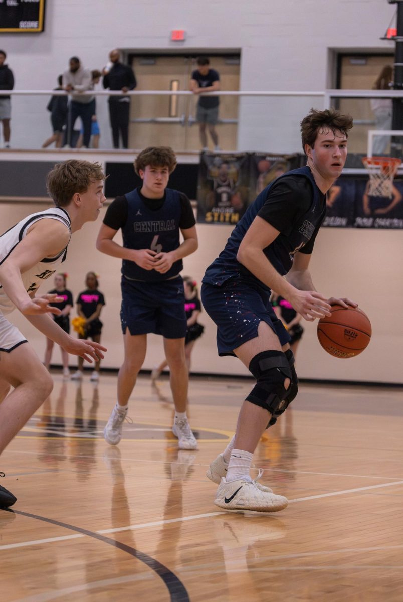 Senior Wyatt Dwyer dribbles with his back to a Howell North defender on Mar. 27. Dwyer uses his size to push through difficult defenses.
