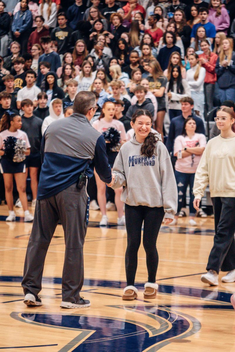 Dr. Gaugh gives Cara Belter a handshake, congratulating her. Belter achieved an Ultimate Spartan GPA award for band.
