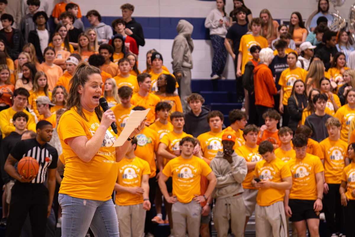 Math teacher Mrs. Fetsch speaks about her journey beating leukemia at the basketball game on Feb. 17. Students went quiet and listened as she shared her story.
