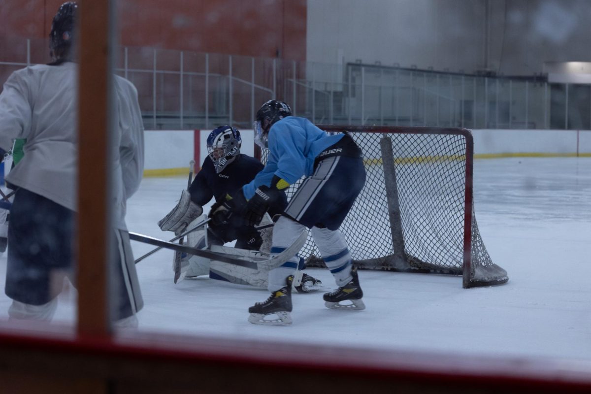 Senior Tyler VonFeldt protects his team's goal while driving the puck away. But, his opponent, Jase Thomason, strives back, making the game challenging.