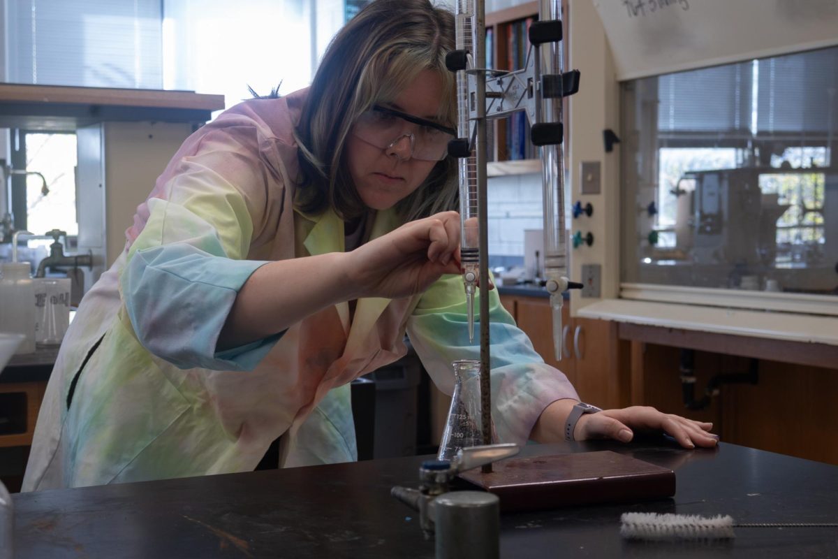 Caption: Chemistry teacher Ms. Moore performs a precise titration experiment in a colorful lab coat. Titrating acids and bases is one of the most infamous experiments in chemistry for being difficult.
