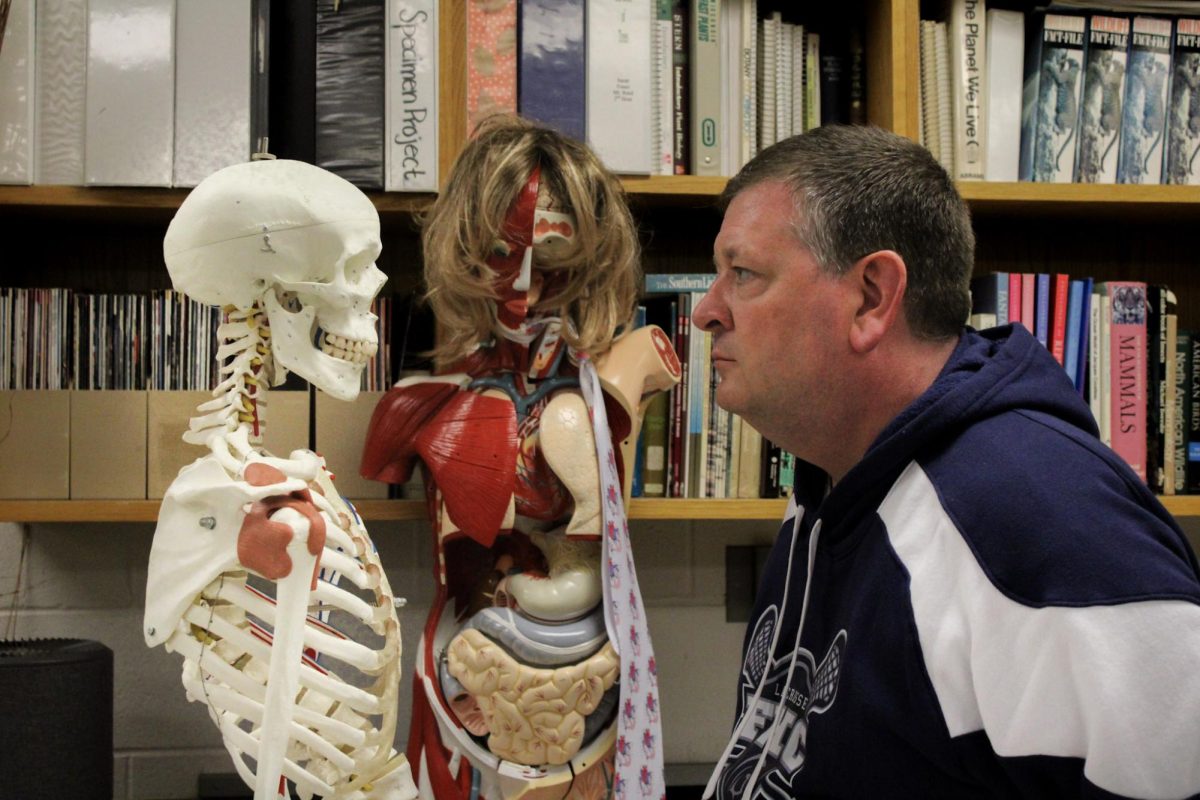 Mr. Patrick Reed looks intensely at his anatomy skeleton, which he has named Mr. Dauve. Reed brings his unique personality to each class, using creative analogies and interesting stories to guide his students to deeper levels of understanding. 
