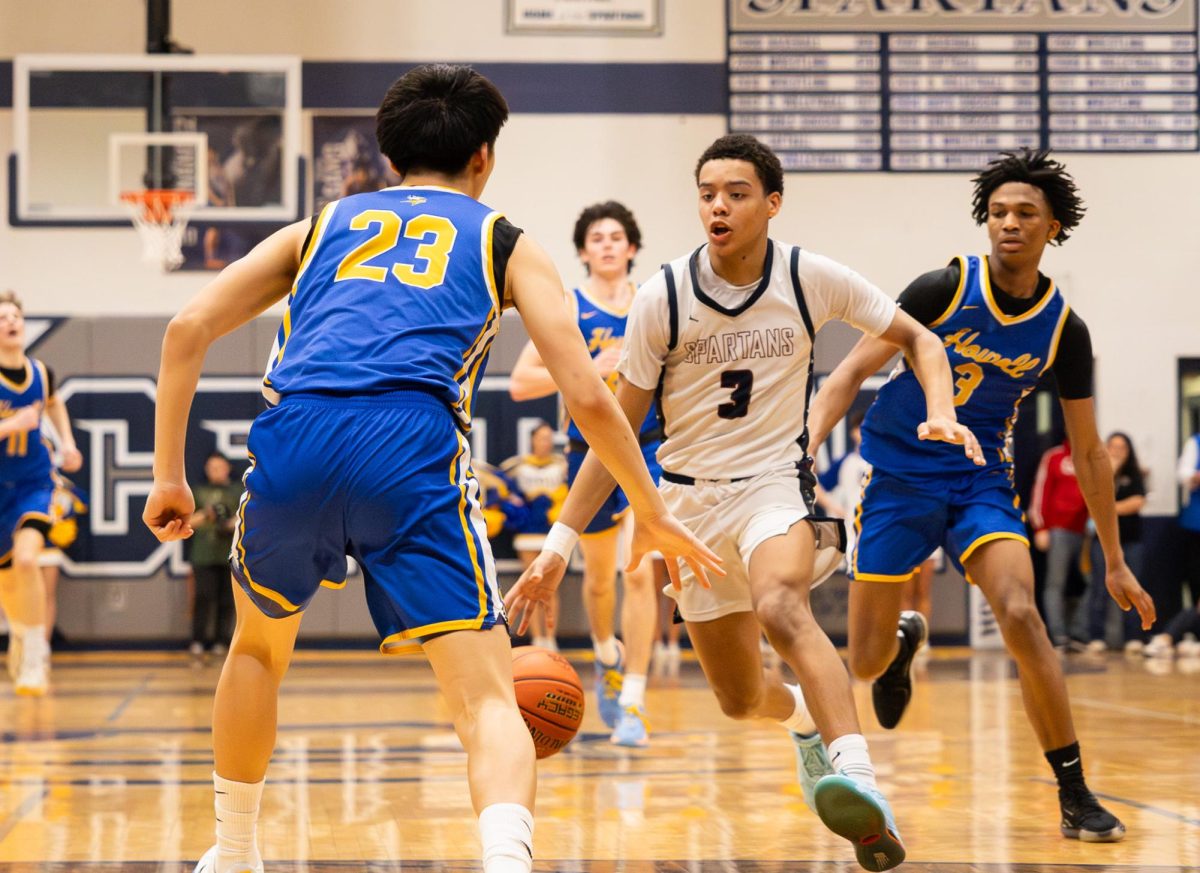 At the basketball game on March 5, junior Jamarious Britt runs down the court, dribbling the ball. After making it past the defenders, Britt passed the ball to his teammates.