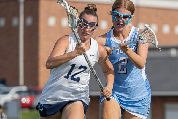 Sprinting away from a St. Dominic player who is directly behind her, sophomore Kaitlyn Jones pushes forward, unfazed by the shoulder check on April 23. Jones’ determination to keep the ball going to St. Dominic’s goal was stronger than any girl could knock down.