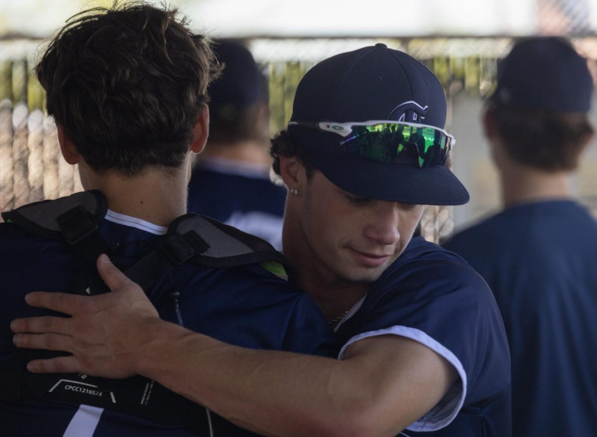 Junior Will Brown hugs sophomore catcher Kyle Goughenour in appreciation for his work in the previous inning on April 25. Goughenour was taken up from junior varsity to catch the game. 