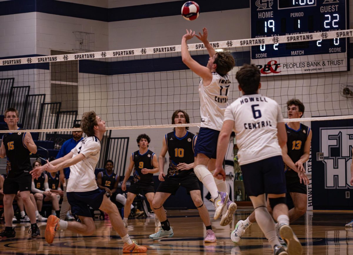Lifting his feet off the ground, junior Josh Hadden prepares the ball in order for senior Dylan Davis to spike. Senior Jason Campbell ran over to assist when the ball came back on April 21.