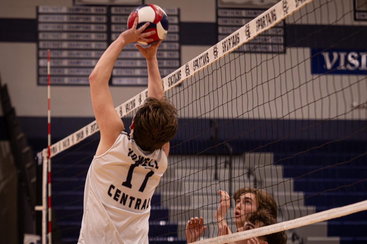 Hitting the ball to the other side of the court during the game against Howell on April. 21, Josh Hadden raises his arms pushing it over the net. The opposing team awaited for the ball to arrive.