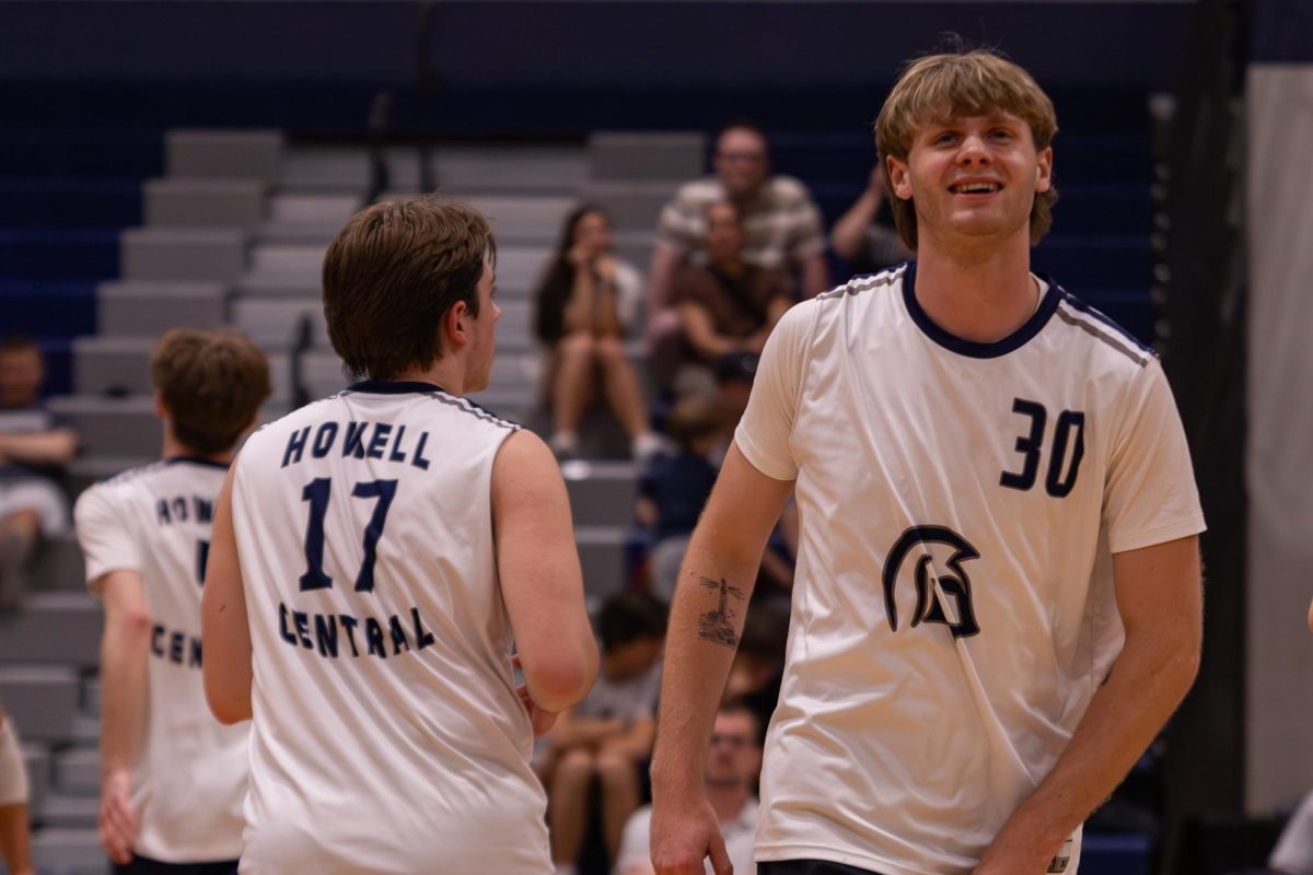 Upon gaining a point for his team, senior Chase Rugh begins to smile, walking back to his position on the court on April. 21. The team gave Rugh pats on the back and cheered him on.