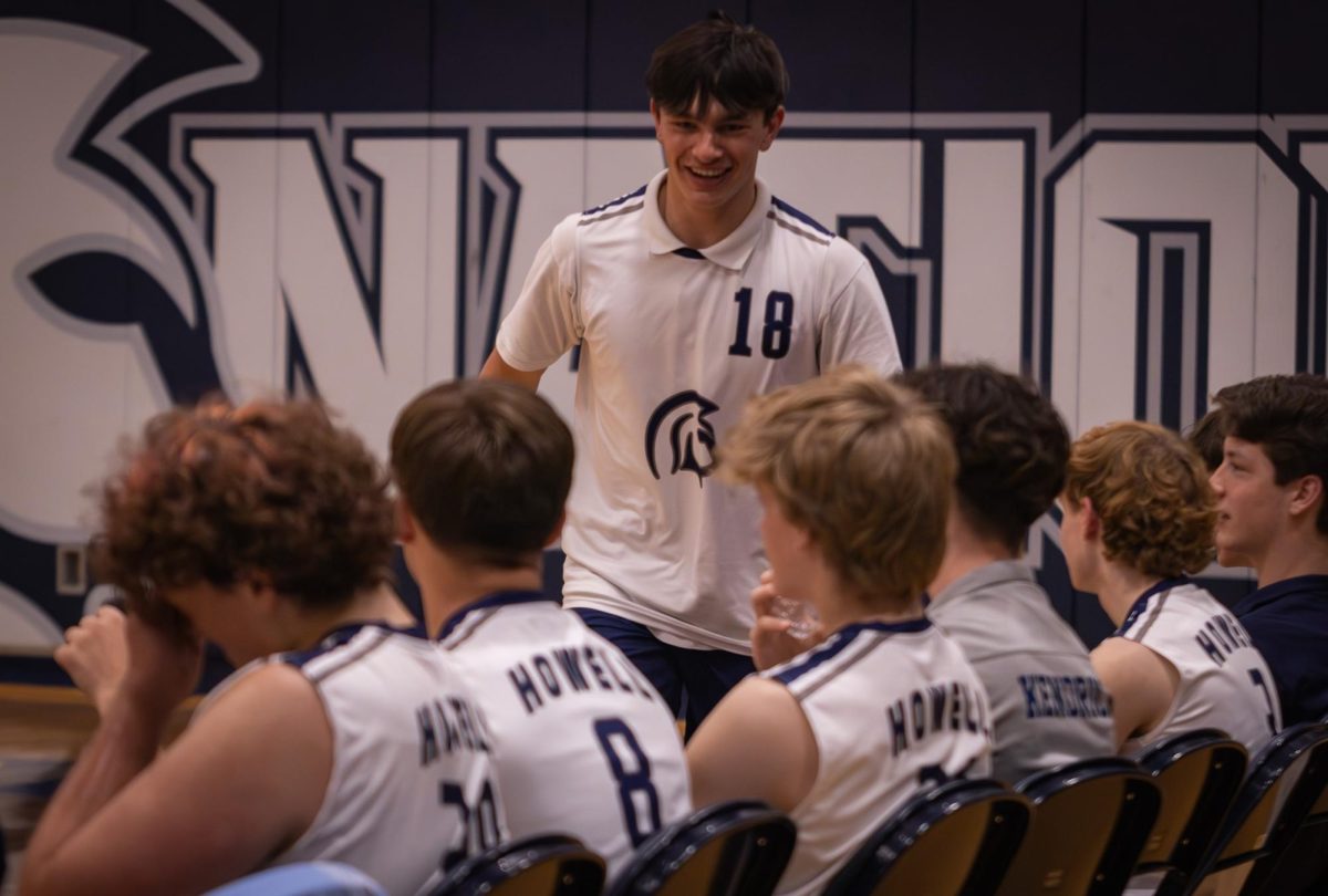 Making his way past the bench on April. 21, junior Danny Maher collected high-fives from his teammates. Maher took a seat with a big smile on his face.